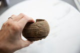 Antique African copper cuff bracelet held in hand to demonstrate its scale and form.