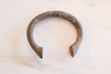 Detail of the unique, textured surface and aged patina on an African copper alloy manilla.
