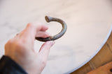 Antique African Copper Alloy Manilla Cuff Bracelet held, with rich, textured copper alloy patina.