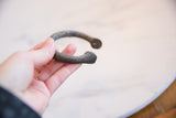 Collector's mid-19th century African manilla bracelet held, showcasing its textured patina.