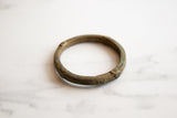 Detailed craftsmanship of geometric patterns on a textured antique bronze bracelet.