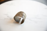 Angled profile of an antique African cuff bracelet showing its etched geometric patterns and patina.
