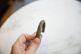 Diagonal line detail on the oxidized bronze and copper surface of the antique cuff.
