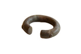 Antique African bronze alloy cuff bracelet with a thick, hand-worked form and dark, aged patina.