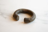 Close-up of the aged patina and hand-scored lines on the bronze cuff.
