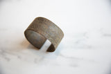 Textured surface of the antique African bronze alloy cuff with faded detailing.