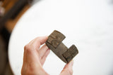 Angled view showing the aged patina and geometric detail on the bronze alloy cuff.