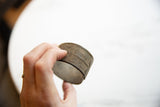Antique African bronze alloy cuff held in hand, highlighting its width and textured patina.