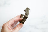 Angled view of the textured surface and craftsmanship of an antique African bronze cuff.