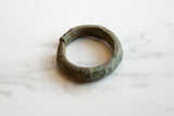 Profile view of a collectible African cuff bracelet highlighting its textured bronze patina.