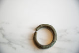 Antique African bronze cuff showing its thick, open shape and dark, textured patina.