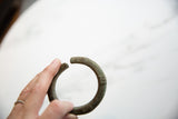Antique bronze cuff bracelet shown in hand to highlight its scale and form.