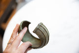 Antique African bronze cuff bracelet held in hand to demonstrate its wearable scale.