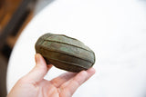 Antique African bronze cuff bracelet held to show its substantial scale and oxidized finish.