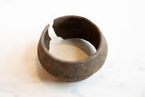 Antique African bronze alloy cuff bracelet showing its irregular opening and patina.