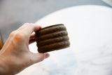 Side profile of antique African bronze alloy cuff, highlighting its raised geometric details and rich patina.