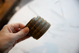 Antique African bronze cuff with ridged geometric details and an aged patina held in hand.