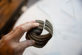 The ribbed profile and aged patina of the antique African bronze cuff's opening.