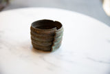 The sculptural form of a wide African bronze cuff bracelet with an aged patina.