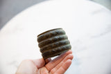 Wide antique African bronze cuff with geometric detailing held to show its scale.