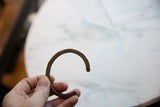 Side profile view of the C-shaped antique African bronze bracelet.