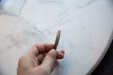 The handcrafted profile and aged patina of the antique bronze bracelet.