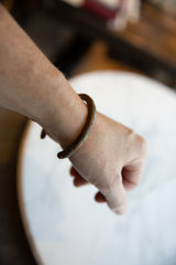 Antique African bronze bracelet with a twisted design, worn to show its scale and fit.
