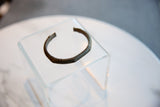 Antique African bronze cuff bracelet displaying its hand-forged shape and worn texture.