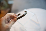 Antique bronze cuff bracelet held in hand to show its scale and aged patina.