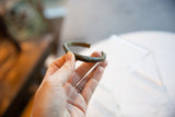 Antique African bronze cuff bracelet held to show its scale and time-softened patina.