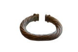 Antique African metal bracelet with a twisted, handcrafted design and an earthy, aged patina.