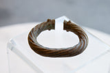 Hand-worked twisted texture and decorative open ends of the antique African metal alloy bracelet.