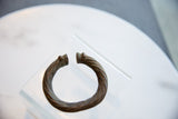 Antique African metal bracelet with a twisted body and open cuff, showing its aged patina.