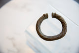 Flared terminals and twisted body of the antique African metal bracelet.