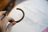 The hand-formed shape and time-softened patina of an antique African copper bracelet.