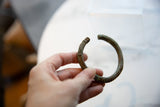 An in-hand view of the antique bronze alloy cuff showing its scale and incised pattern.