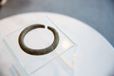 The ribbed texture and aged patina of a handmade African bronze bracelet.