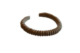 Antique African copper cuff bracelet with a ribbed texture and dark, time-worn patina.
