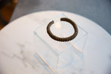 The handcrafted, striped texture and rich patina of an antique African copper cuff bracelet.