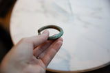 The substantial form and aged, striped patina of an antique copper cuff.