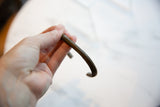 Aged patina and linear texture on the curved profile of an antique copper bracelet.