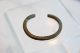 Detail of the antique bronze cuff showing its aged patina and signs of historic use.