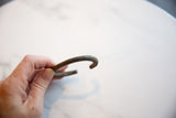 The curved silhouette and aged patina of the antique bronze child's cuff bracelet.