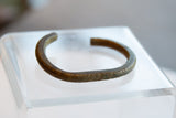 Side profile of an antique bronze cuff showing its aged patina and geometric detailing.