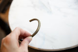 The smooth curve and aged surface patina on the antique African bronze cuff.