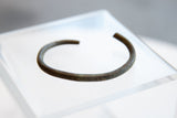 The distinct oxidized patina and simple form of a collectible African cuff.