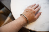 Antique African cuff bracelet worn on a wrist showing its scale and patina.