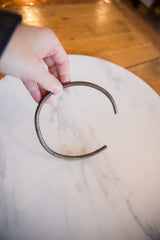 Hand holding the vintage African bronze artifact to show its scale and form.