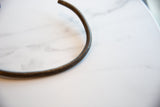 Etched geometric texture on the curved surface of a vintage bronze artifact.
