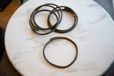 A single vintage African bronze ring displayed next to a stack of several others.